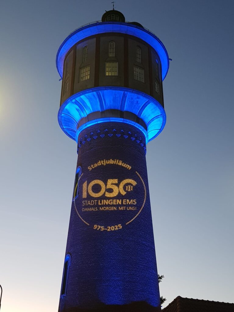 1050 Jahre Lingen, Wasserturm erstrahlt in Blau mit Logo.